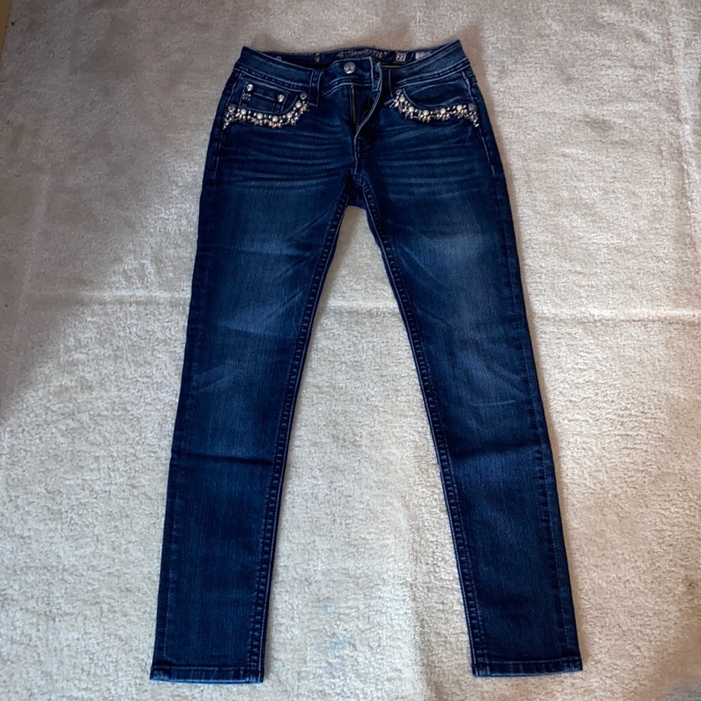 Miss Me mid-rise skinny jeans with pearl and jewel pockets.